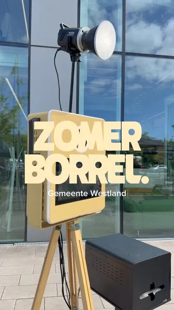 De fotobooth op statief voor een bord met de tekst Zomerborrel Gemeente Westland